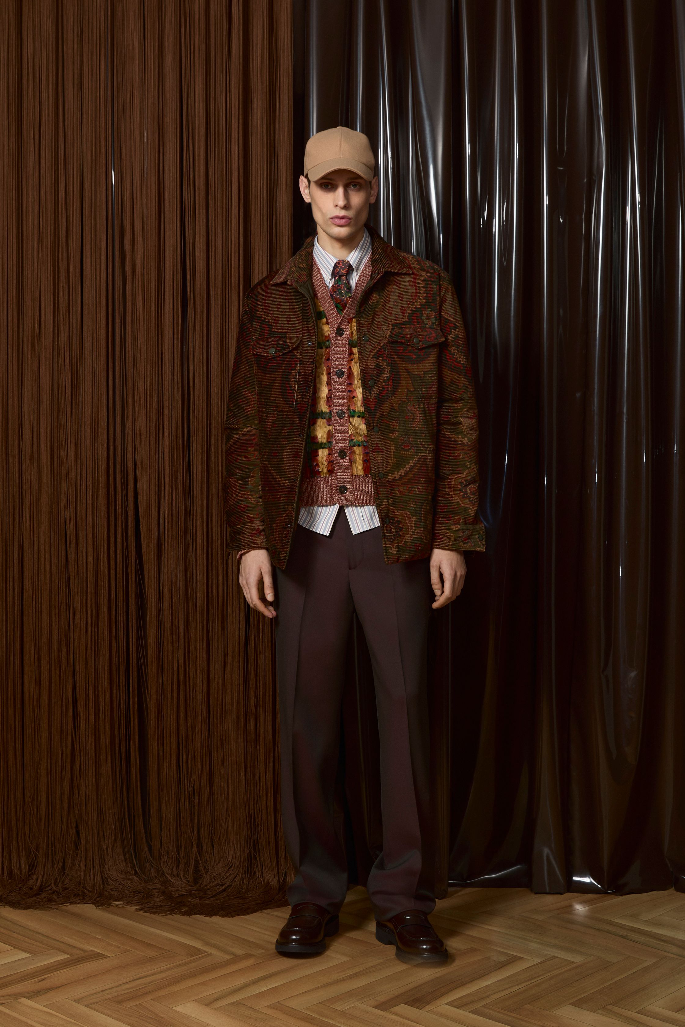 Etro 2026秋冬延续品牌标志性的波西米亚精神，却以更成熟、更男性化的方式呈现。提花针织、佩斯利纹样与复古皮革相互碰撞，营造出知识分子气质与旅行者浪漫并存的形象。整体色调趋向深棕、酒红与森林绿，使装饰性回归内敛，完成一次从“浪漫叙事”到“文化穿着”的进化-顽石频道趋势研究